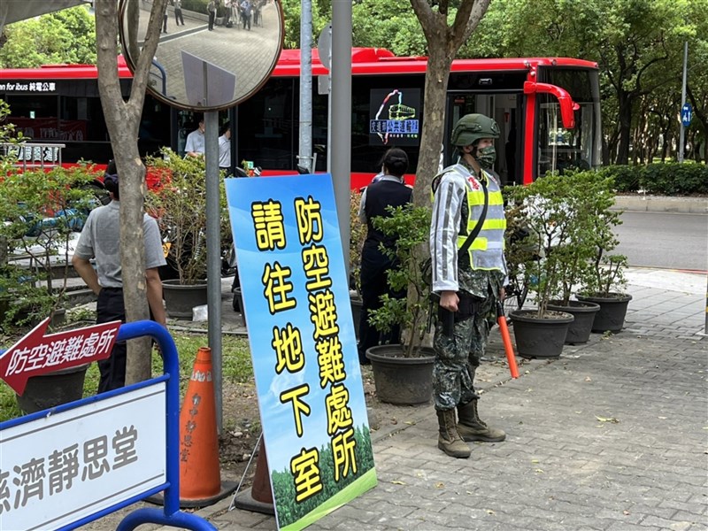 A soldier stands next to a sign that says "head to the basement for the air raid shelter" during the Wanan air defense drills in Taichung in July 2022. CNA file photo