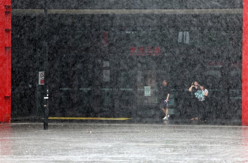 Pedestrians take shelter from the rain at the entrance of a department store in Taipei closed because of Typhoon Gaemi on Wednesday. CNA photo July 24, 2024