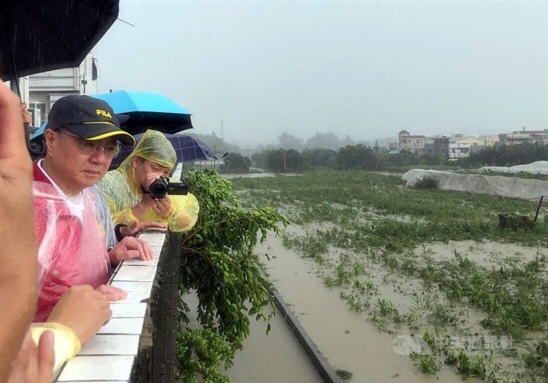 Premier Cho Jung-tai (left) inspects damage to a papaya farm in Chiayi County Friday. CNA photo July 27, 2024