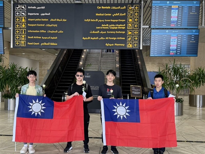 Taiwanese high school students Lin Jun-yu (from left), Chen Jiun-ze, Li Chia-wei and Ko Yen-hung pose with Republic of China flags at the air port in Saudi Arabia in this recent photo. Photo courtesy of Ministry of Education July 30, 2024