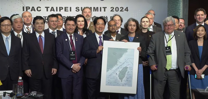 President Lai Ching-te (center left, holding Taiwan map) pose with foreign parliamentarians at the IPAC Taipei Summit on Tuesday. Image taken from CNA video