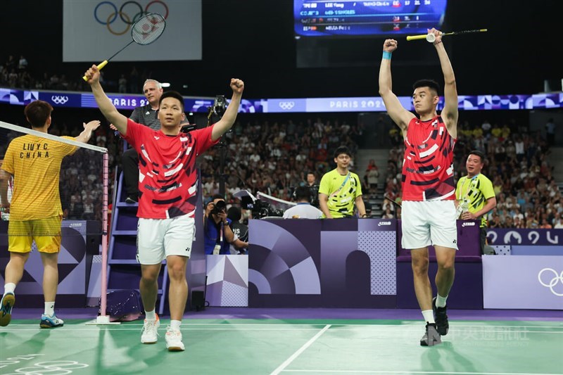 Lee Yang (in red, left) and Wan Chi-lin cheers after winning a group stage game at the Paris Games on Wednesday. CNA photo July 31, 2024