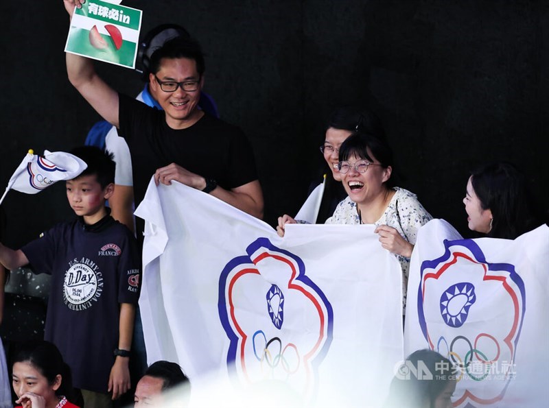 Taiwanese fans holding the Chinese Taipei Olympic flag celebrate the gold medal win of Taiwanese badminton duo Lee Yang and Wang Chi-lin at the Paris court on Sunday. CNA photo Aug. 4, 2024