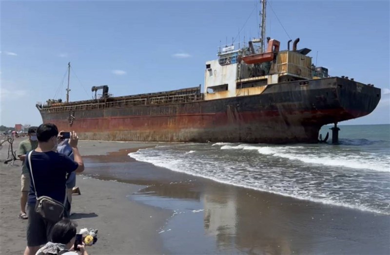 People take pictures of the Togo-registered cargo ship Sopfia, which became an attraction site after it ran aground on the Tainan coast when Typhoon Gaemi hit Taiwan last month, on Aug. 6. File photo courtesy of a private contributor