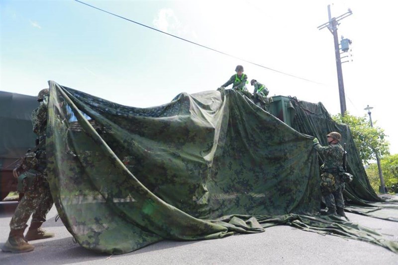 Soldiers cover up a telecommunications equipment using camouflage netting during the Han Kuang military exercises in July. File photo courtesy of the Military News Agency