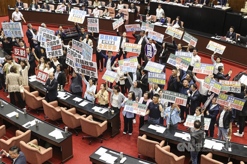 Lawmakers of the Democratic Progressive Party hold placards at the center of the legislative chamber during the review of the 2025 central government budget Friday. CNA photo Oct. 4, 2024