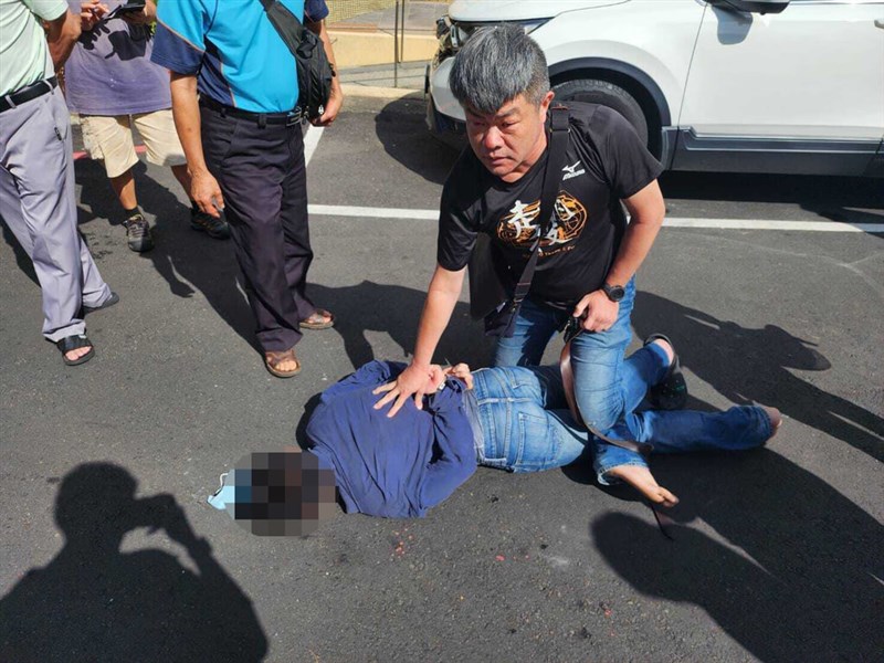 Cheng Chao-cheng (鄭朝成, right, in black), a police squad leader, pins down a robbery suspect in Hsinchu County Sunday. Photo courtesy of a private contributor Oct. 20, 2024