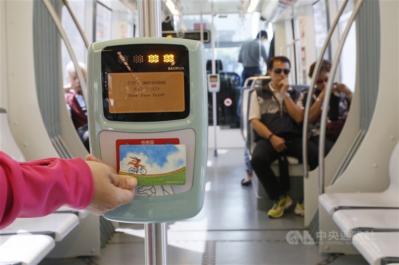 A passenger taking a tram in Kaohsiung taps a card on the card reader to pay for the ride in 2017. CNA file photo