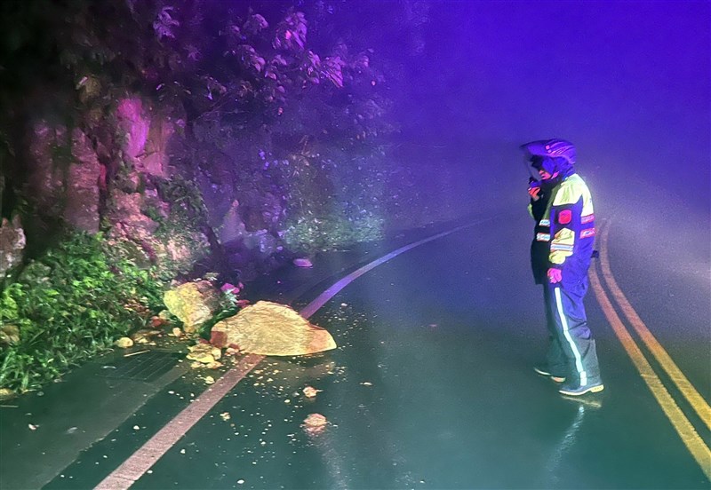 A policeman reports falling rocks along a road in Ruifang District, New Taipei Wednesday evening. Photo courtesy of a private contributor Oct. 30, 2024