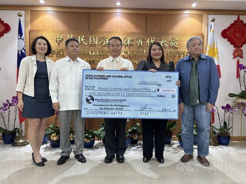 Taiwan's representative to the Philippines, Wallace Chow (center), presents a donation check to his Filipino counterpart, Cheloy E. Velicaria-Garafil (second right), at the Taipei Economic and Cultural Office in the Philippines on Thursday. CNA photo Oct. 31, 2024