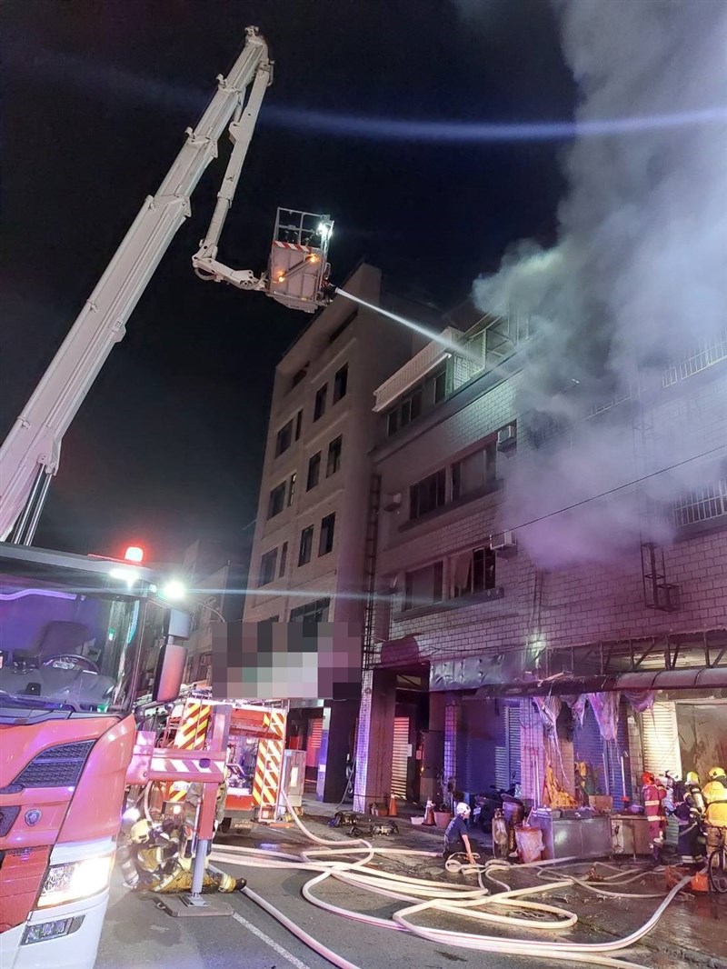 Firefighters extinguish a blaze that broke out at a three-story house in Kaohsiung. Photo courtesy of the Kaohsiung police department's Sanmin second precinct.