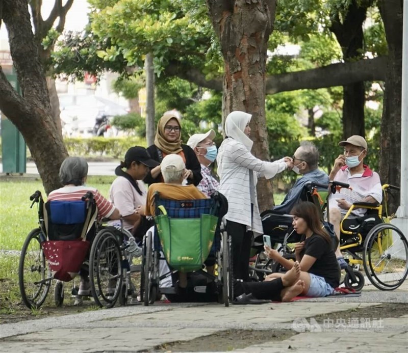 Migrant workers and their care recipients take a break at a Kaohsiung park. CNA file photo