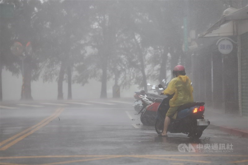 A scooter rider in Taipei's Neihu District braves the rain and wind amid a passing typhoon in October 2024. CNA file photo