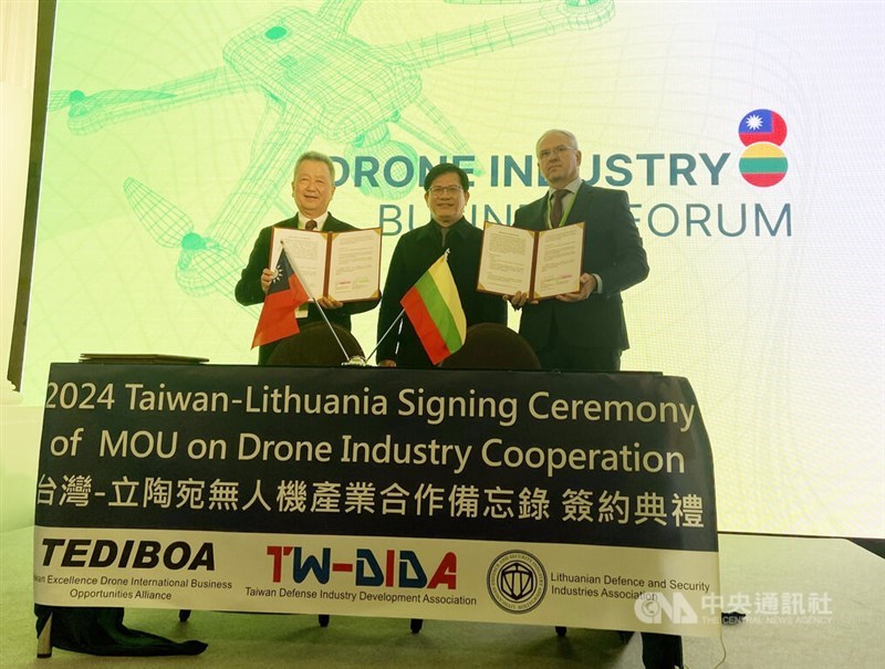 AIDC Chairman Hu Kai-hung (left) and director of the Lithuanian Defence and Security Industries Association Vaidas Sabaliauskas hold the MOUs during a signing ceremony witnessed by Taiwan's Foreign Minister Lin Chia-lung (center). CNA photo Nov. 22, 2024