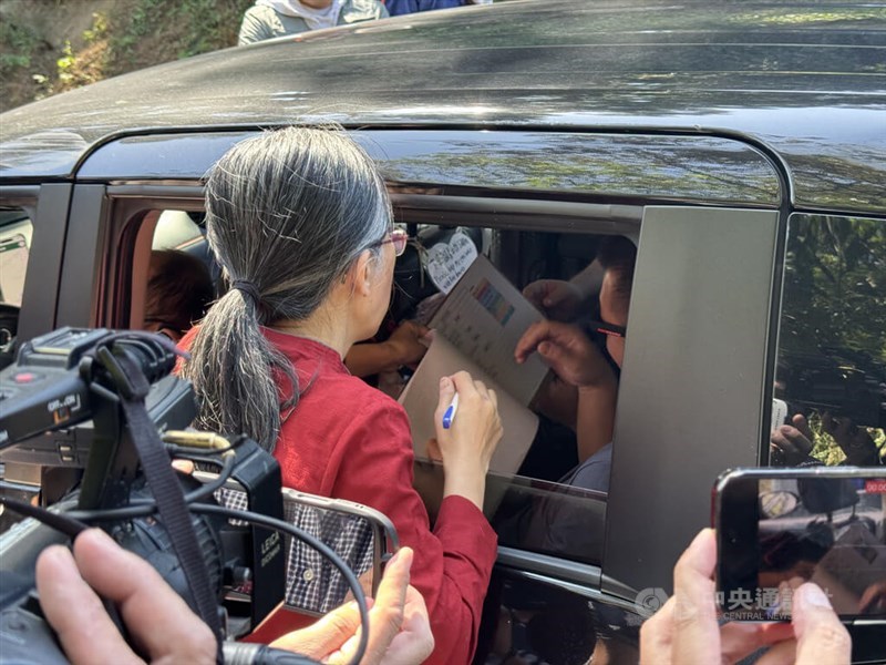 A worker of the Hsinchu County venue where Bo got married checks the invitation of a guest on Saturday under the eyes of local media. CNA photo Nov. 23, 2024