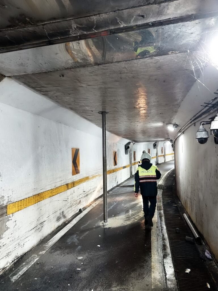 A police officer walks past a steel drill pipe which had pierced through the ceiling of a motorcycle underpass in New Taipei's Tamsui District. Photo courtesy of the New Taipei Public Works Deparment