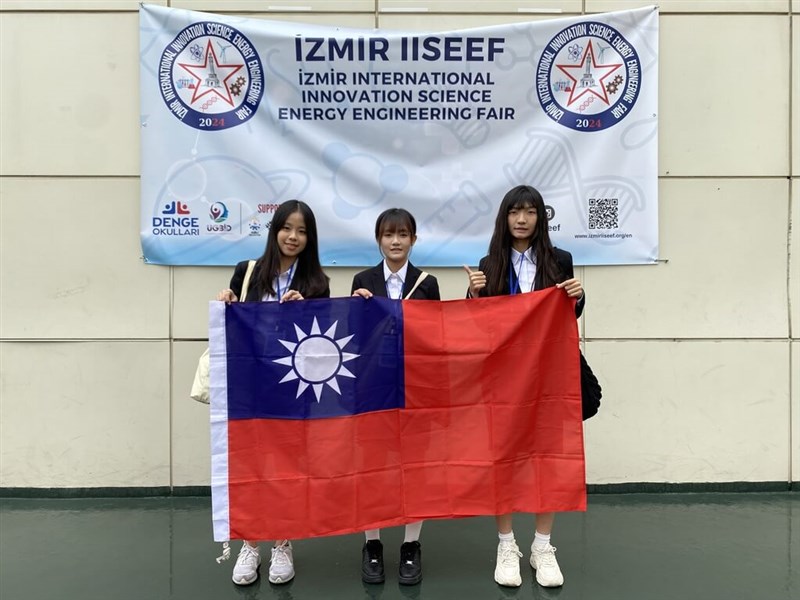 Taiwanese students Chung Chiao-yun, (from left) Chiang Yen-tzu and Huang Yu-han pose with a Republic of China (Taiwan) flag at the Izmir International Innovation Science Energy Engineering Fair in Turkey in this undated photo. Photo courtesy of National Taiwan Science Education Center Dec. 3, 2024