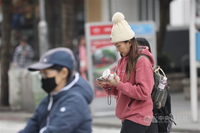 People on the streets in Xinyi District in Taipei keep themselves warm by wearing fur hats and winter clothes. CNA file photo