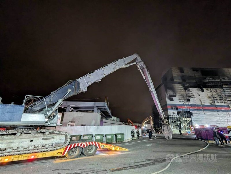 Cranes remove debris from the charred remains of a Taichung PX Mart facility that caught fire Thursday afternoon. CNA photo Dec. 19, 2024