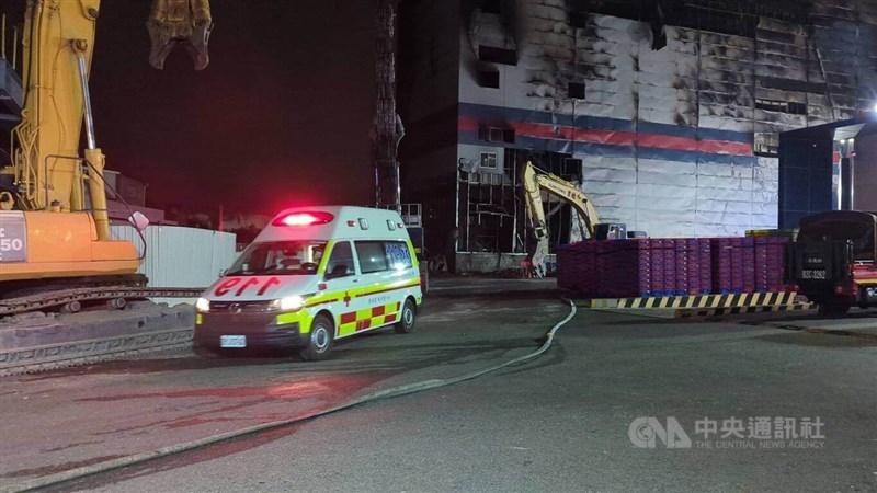 An ambulance carries victims' bodies from the charred remains of a Taichung PX Mart facility that caught fire Thursday afternoon. CNA photo Dec. 19, 2024