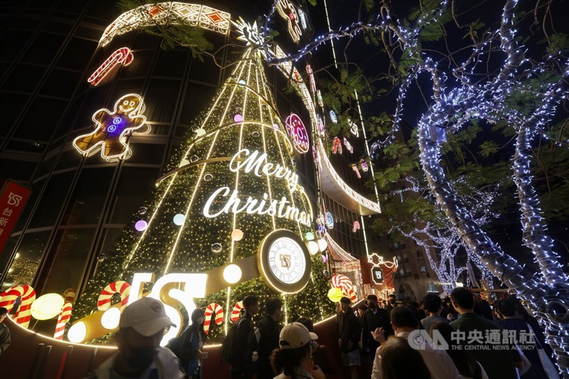 Members of the general public take pictures of a giant Christmas tree erected by Taishin Financial Holding in front of its main building. CNA photo Dec. 6, 2024