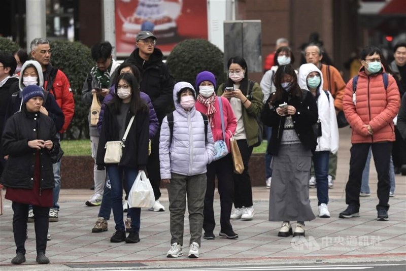 People waiting to cross a street in Taipei brace the recent chilly weather in northern Taiwan. CNA file photo