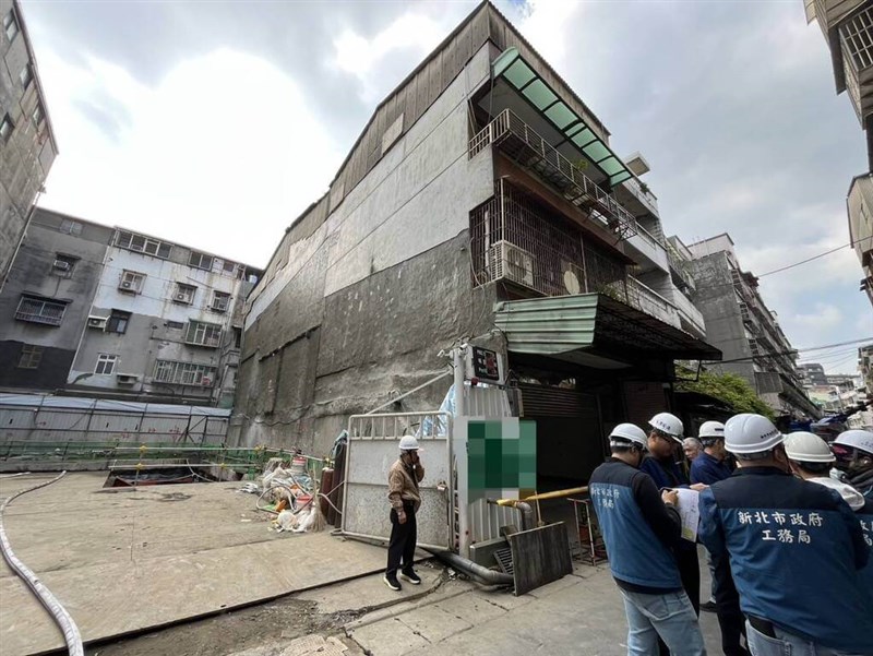 The construction project in New Taipei's Sanchong District which apparently caused a nearby apartment building to tilt Monday morning, leading to the evacuation of 22 residents. Photo courtesy of New Taipei City Fire Department