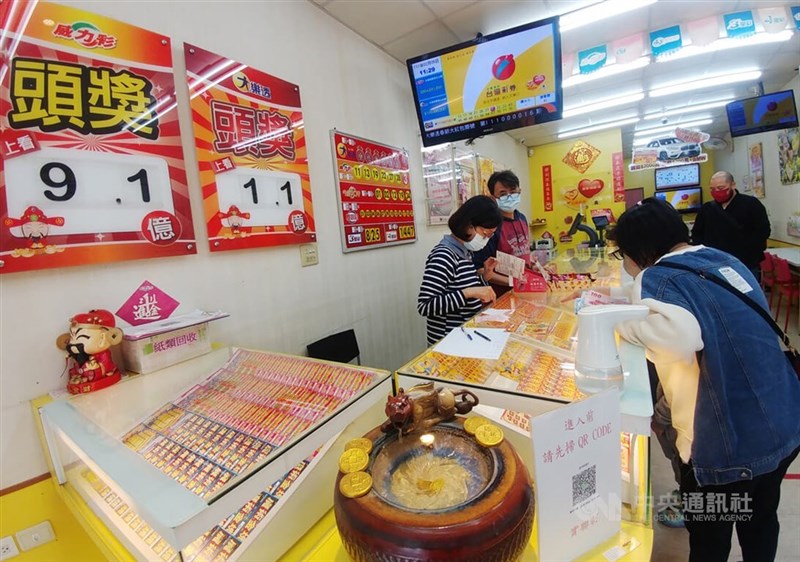 Customers purchase scratchers and lottery tickets from a vendor in CNA file photo