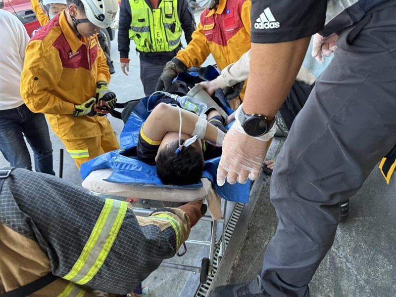 A Vietnamese national employed at a food processing company's factory in Yunlin County gets carried onto a gurney to be transported to a hospital after his right hand was caught in a meat grinder on Monday. Photo courtesy of Yunlin County Fire Department