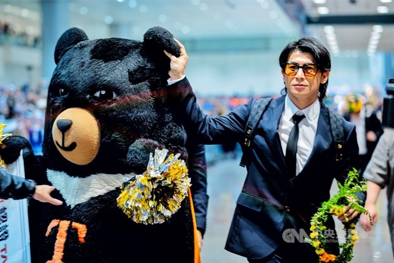 Chen Chieh-hsien takes a photo with a mascot Formosan Black Bear after returning to Taiwan following a win at the 2024 WBSC Premier12. CNA file photo