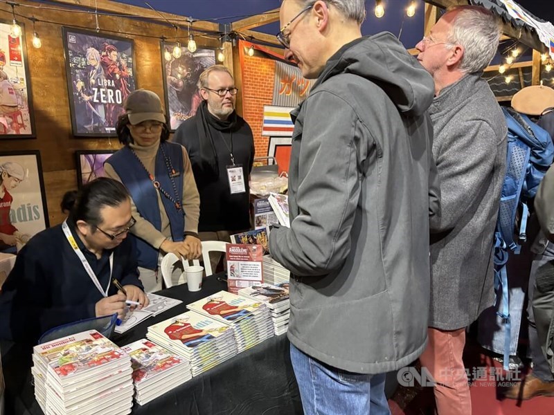 Taiwanese comic book artist Ruan Guang-min (left) signs for fans at Angoulême International Comics Festival in France. CNA photo Feb. 4, 2025