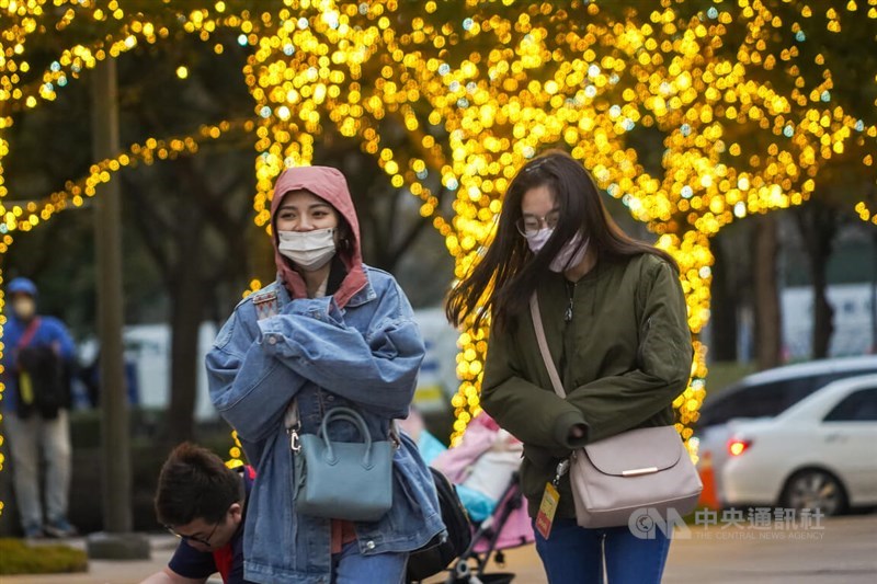 Members of the general public brave the cold while walking around Taipei Friday. CNA Feb. 7, 2025