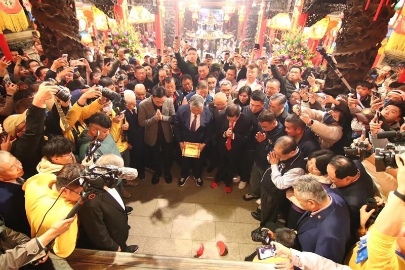 Worshippers gather to witness the results after Yen Ching-piao, chairman of the Jenn Lann Temple board, cast two crescent-shaped divining blocks onto the ground before the statue of Mazu during a ceremony seeking divine guidance for this year's pilgrimage. Photo courtesy of Jenn Lann Temple Feb. 12, 2025