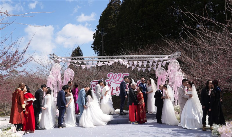 Grooms and brides kiss during a group wedding in the mountainous district of Wufong in Taichung on Wednesday. Photo courtesy of Tri-Mountain National Scenic Area Headquarters Feb. 19, 2025