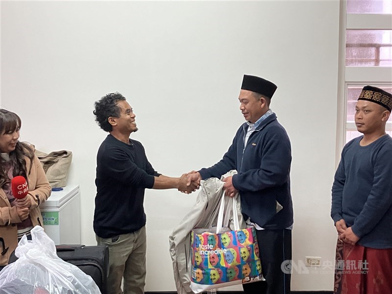 Imam Edi (center right) shakes hands with Arie (center left), a Catholic priest, as he receives a bag of clothes from the Saint Christopher Church and a hiking group. CNA photo Feb. 23, 2025