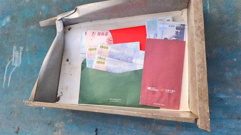 Envelopes with cash are discovered stowed inside an old office desk. Photo courtesy of the Nantou City Office