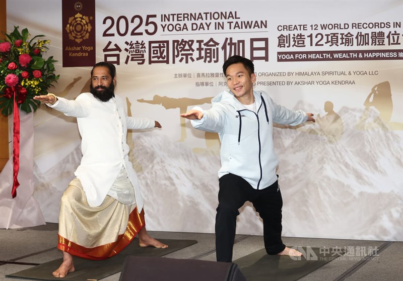 Retired Taiwanese badminton superstar Lee Yang (李洋, right) and yogi Himalayan Siddhaa Akshar demonstrate yoga moves during a news conference Monday to promote a 5,000-person world-record yoga event slated on June 21. CNA photo March 10, 2025