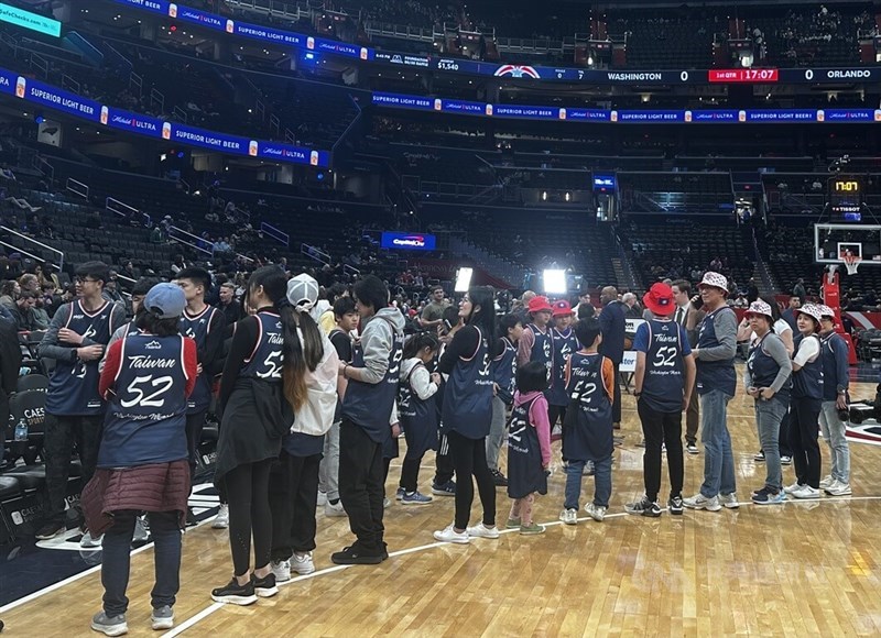 Taiwanese fans wait in line to high-five the Washington Wizards during their home court entrance on Friday. CNA photo March 22, 2025.