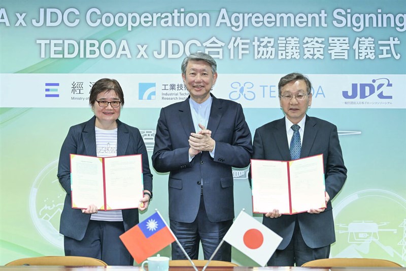 Wu Hsiu-hui (吳秀蕙, left), co-chair of TEDIBOA and chairwoman of Coretronic Corp., JDC Chairman Kenzo Nobuo (right) display copies of a memorandum of understanding (MoU) they signed under the witness of Minister of Economic Affairs Kuo Jyh-huei (郭智輝, center) on Tuesday. Photo courtesy of the Aerospace Industrial Development Corp. (AIDC) March 25, 2025