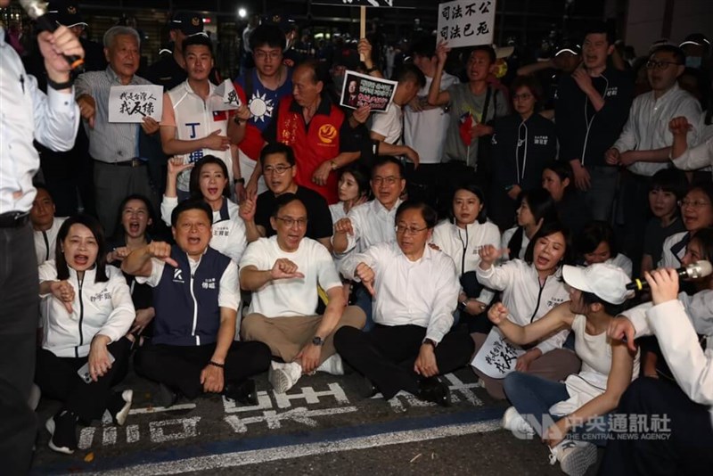 KMT Chairman Eric Chu (3rd, front left), KMT caucus whip Fu Kun-chi (2nd, front left) and Taoyuan Mayor Chang San-cheng (4th, front left) sit on the ground outside the Taipei District Prosecutors Office during a protest on Thursday evening. CNA photo April 17, 2025