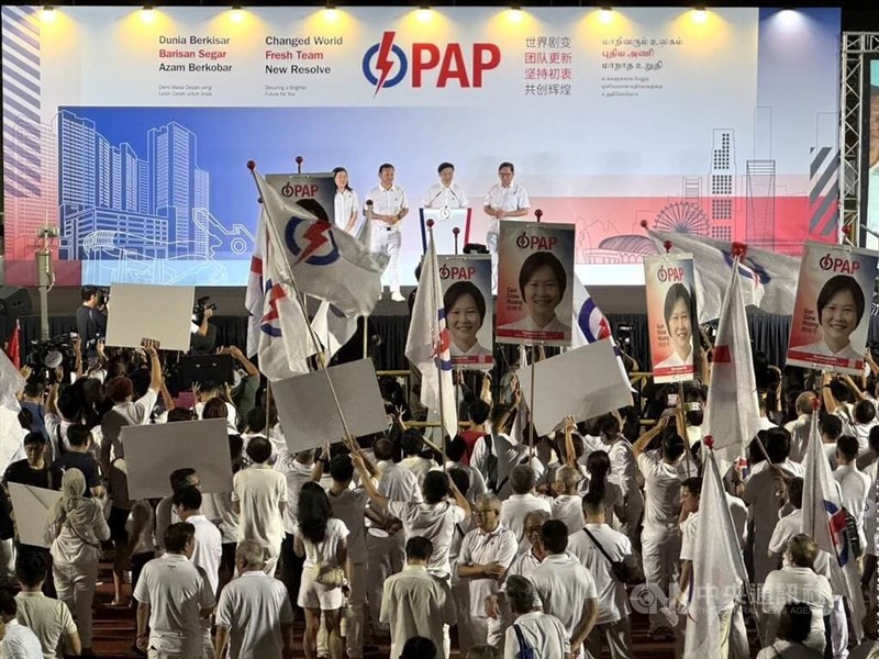 Singapore Prime Minister Lawrence Wong (second from right on stage) gives a speech after his party won a landslide victory in Sunday's general elections.