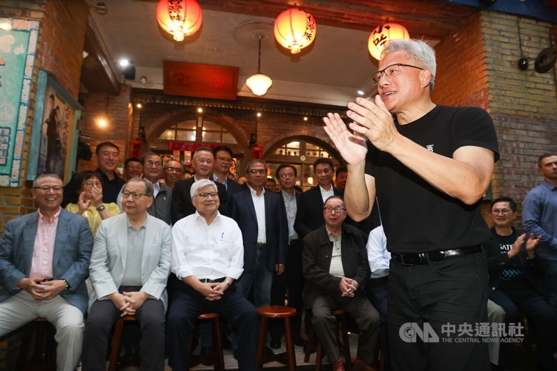 Nvidia founder and CEO Jensen Huang readies the heads of his company's partners for a group photo before a dinner on Saturday. CNA photo May 17, 2025
