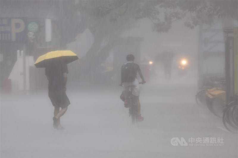 Taipei pedestrians escape a heavy rain in this CNA file photo
