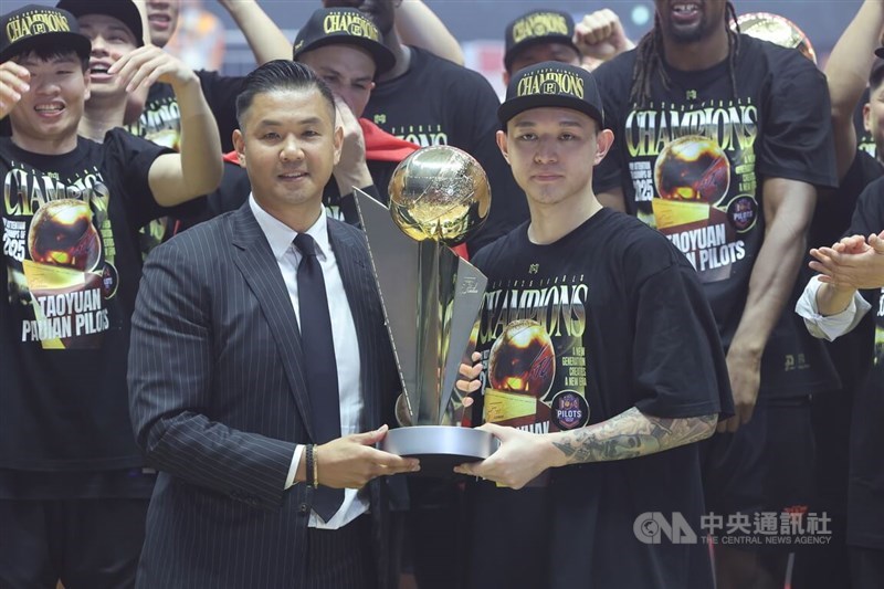 PLG Vice Chairperson Charles Chen (left) presents MVP Lu Chun-hsiang (right) with the Pilots' P.LEAGUE+ title trophy on Wednesday. CNA photo May 21, 2025