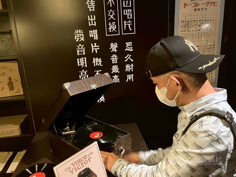 A man operates a portable phonograph at the “Modern Era: The Dawn of Pop Music” exhibition in Taipei. CNA photo May 23, 2025