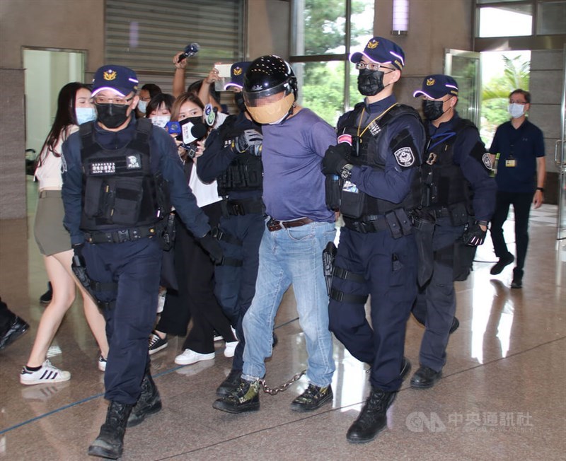 Nantou police officers escort culprit Lee Hung-yuan, a former employee of Kang Jian. CNA file photo