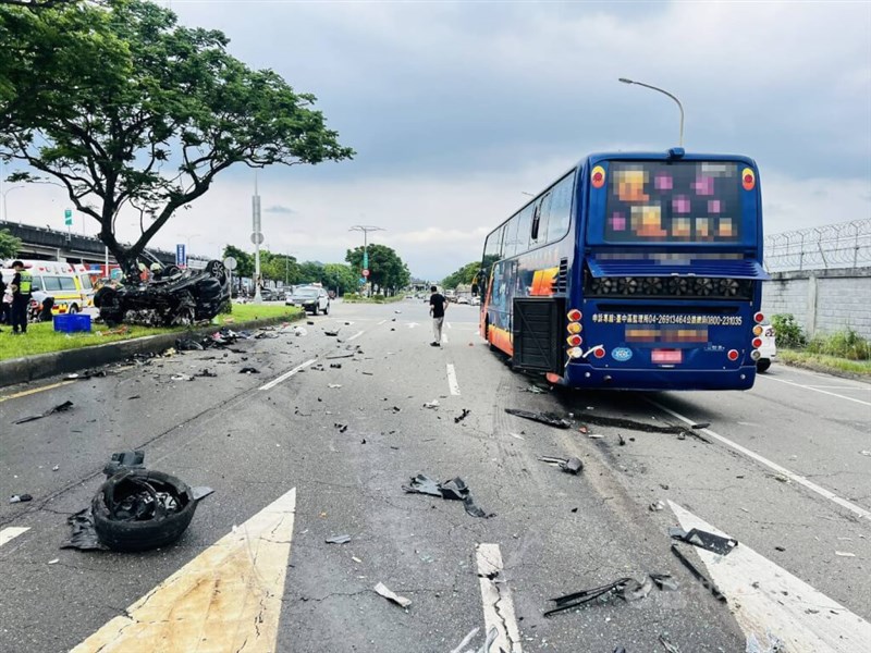 A sedan is seen overturned on a road divider after colliding with a tour bus in Taipei on Saturday. Photo courtesy of local police