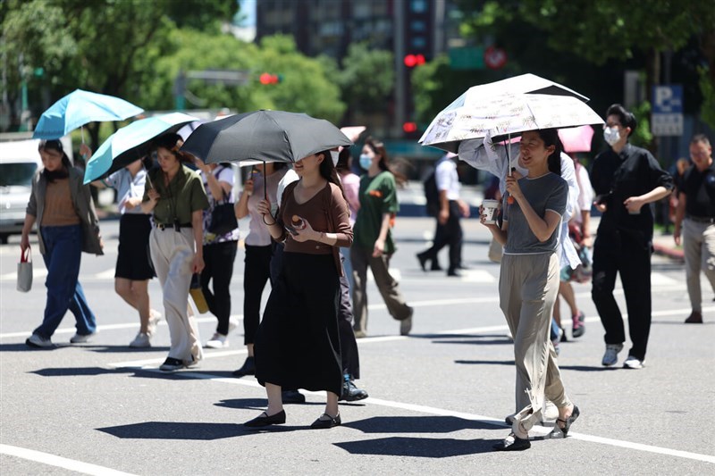 Pedestrians in Taipei hold umbrellas to shield themselves from the heat Wednesday. CNA photo June 11, 2025