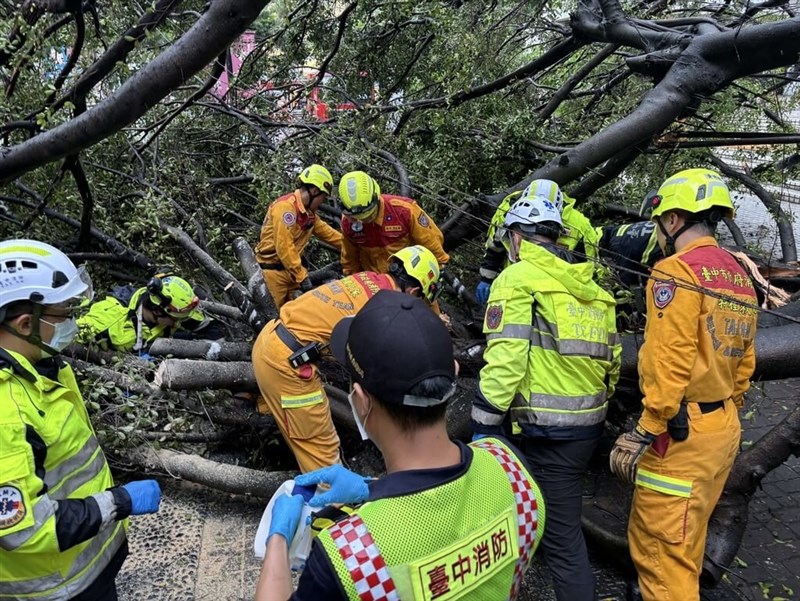 Rescue workers pull out a student who was crushed by a fallen tree at Feng Chia University in Taichung on Friday. Photo courtesy of the city’s Fire Bureau