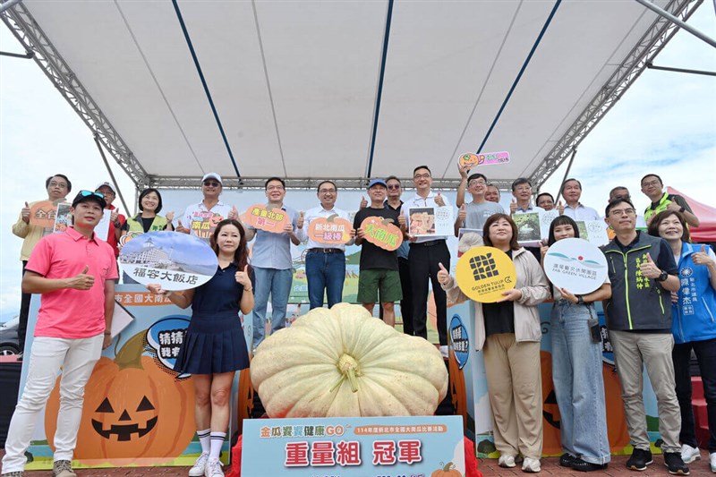 Farmer Lin Chien-hsun (seventh left in back) poses with New Taipei Mayor Hou Yu-ih (sixth left in back) behind the former's award-winning heavy pumpkin. Others at the event include other competitors and also New Taipei agricultural officials. Photo courtesy of the New Taipei Department of Information